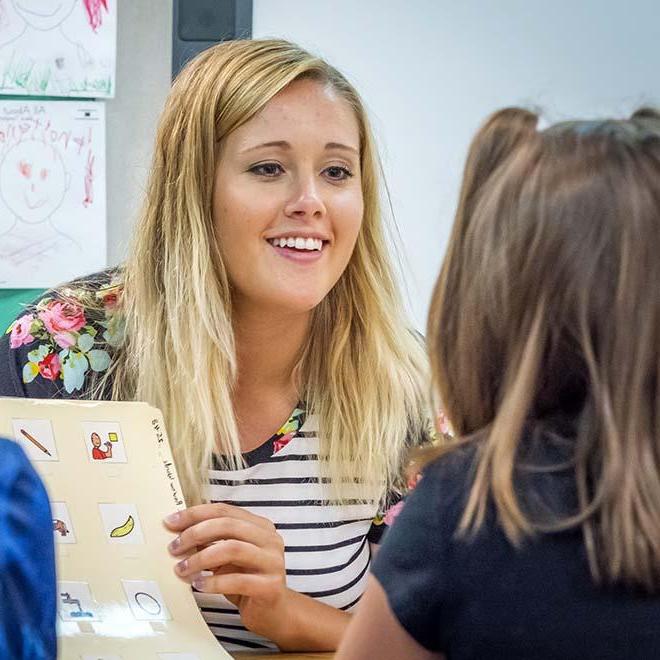  Young female teacher working on lessino with young student